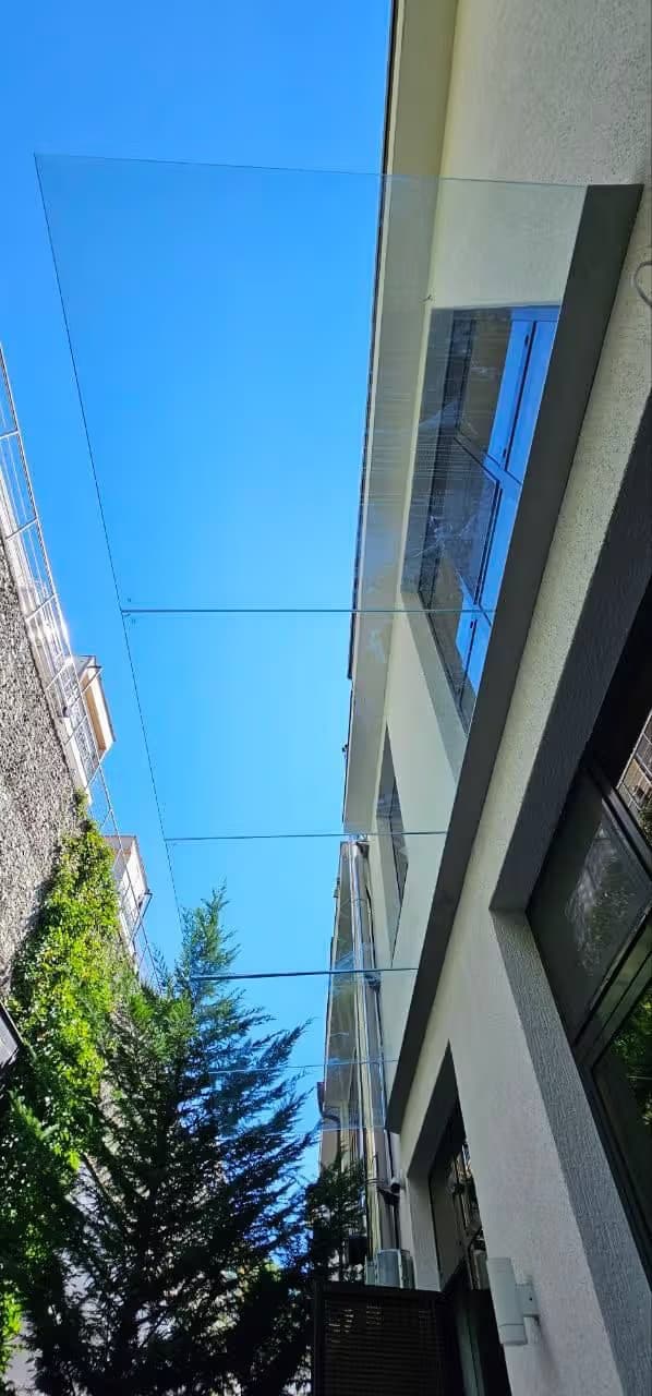 Стеклянный пятиполосный козырёк в зажимном профиле над входом, Адлер — изготовление и монтаж под ключ