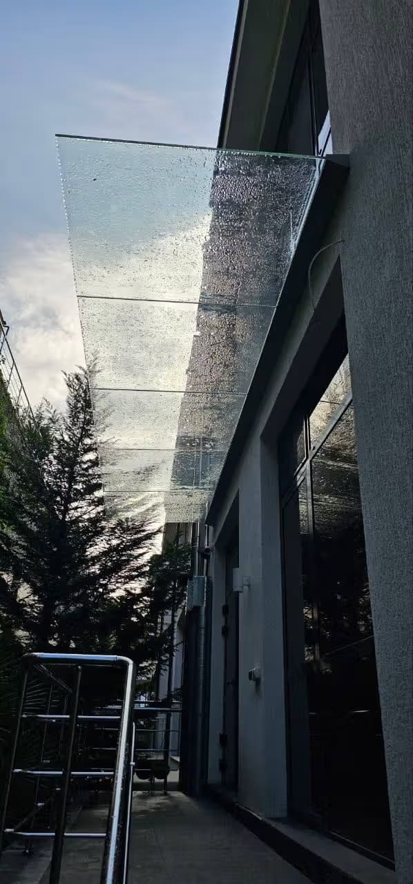 Стеклянный пятиполосный козырёк в зажимном профиле над входом, Адлер — изготовление и монтаж под ключ