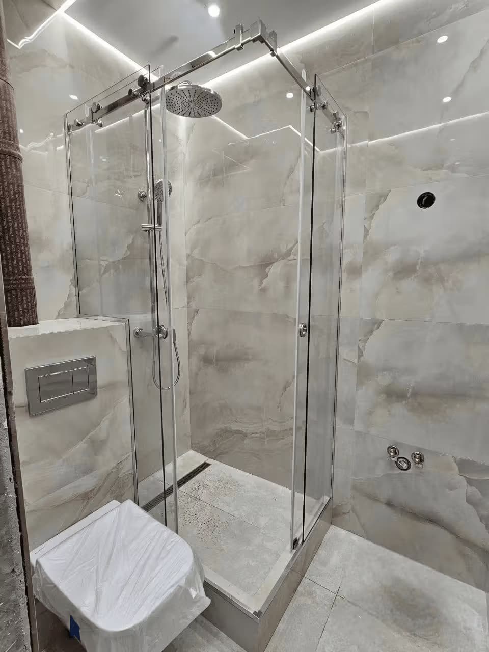 Угловая раздвижная душевая кабина, частично встроенная в нишу, из закалённого стекла с хромовой фурнитурой, Сочи — изготовление и монтаж под ключ