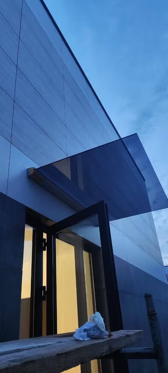 Козырек из стекла в зажимном профиле над входом в частном доме в Адлере, Сочи — производство и установка под ключ